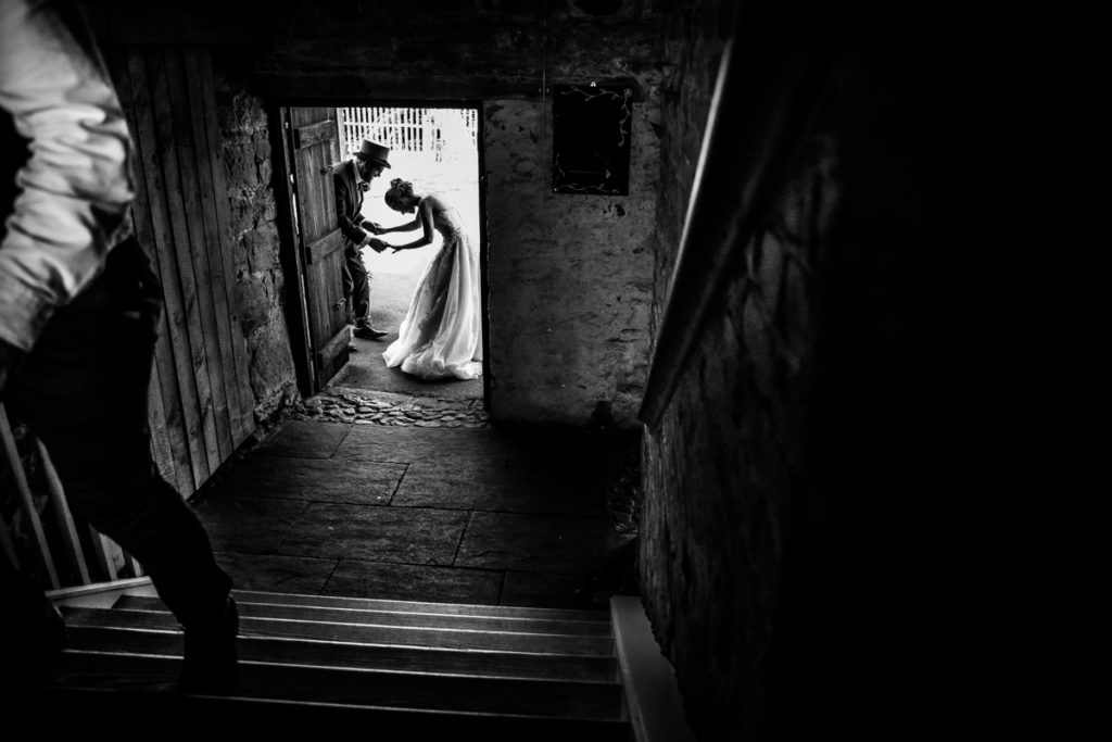 lake district documentary wedding photographer Askham Hall laughing in the door in black and white