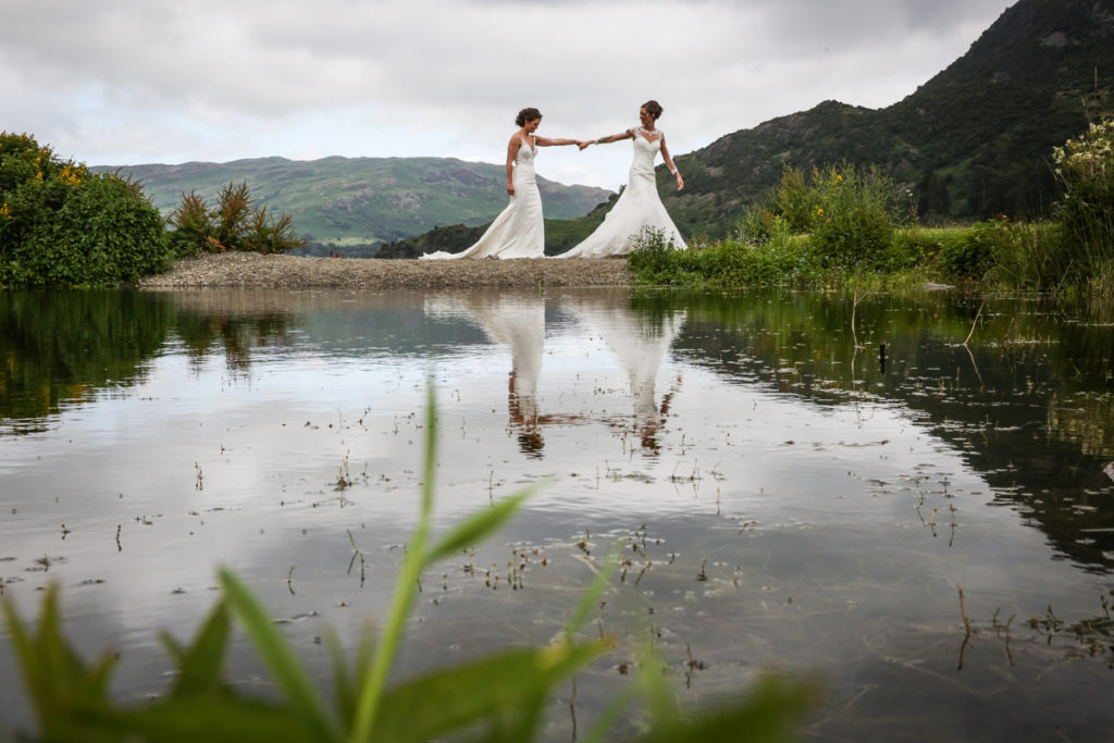 lake district documentary wedding photographer The Inn on The Lake two brides by the lake with reflection