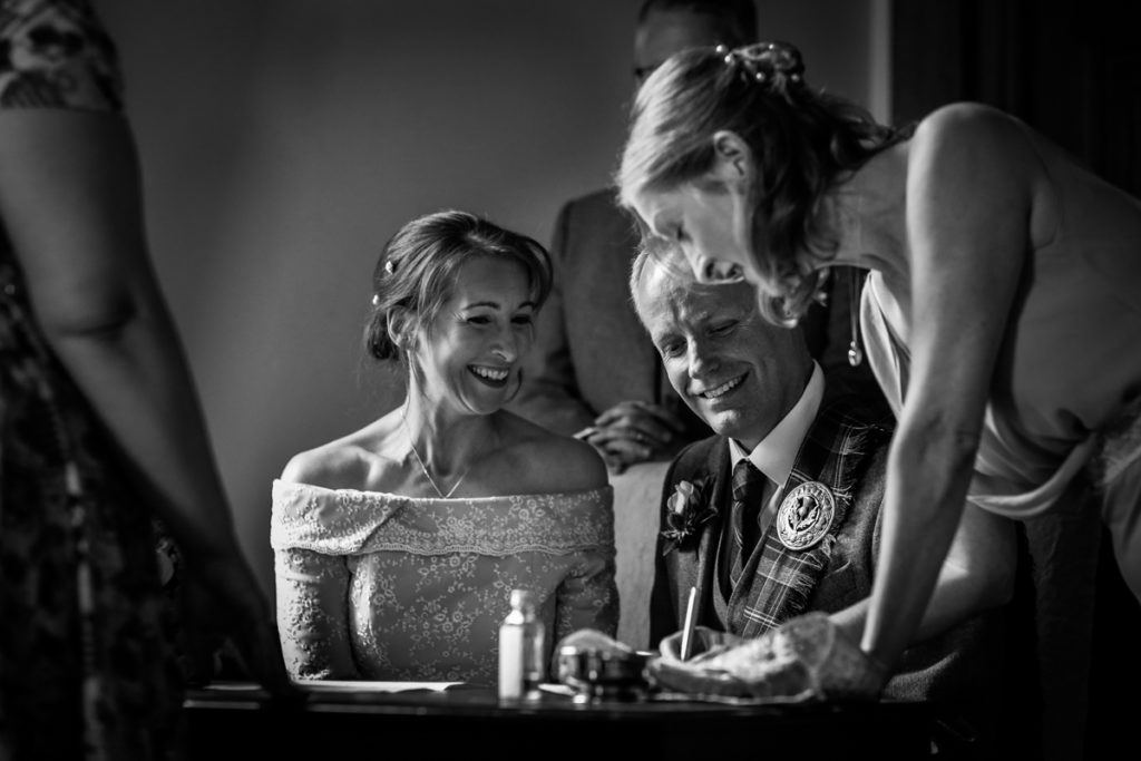 lake district documentary wedding photographer Springkell signing the register black & white