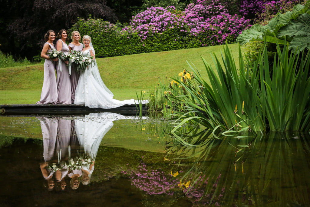 lake district documentary wedding photographer Merewood bridesmaids in a spring garden with reflection