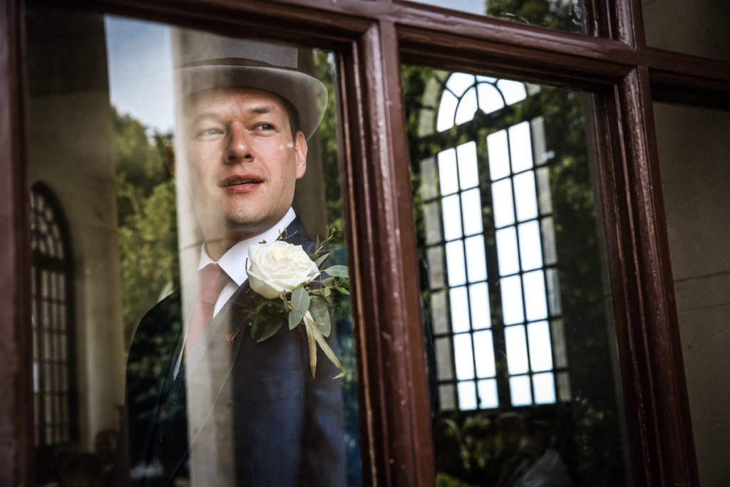 lake district documentary wedding photographer Ashton Memorial groom in window