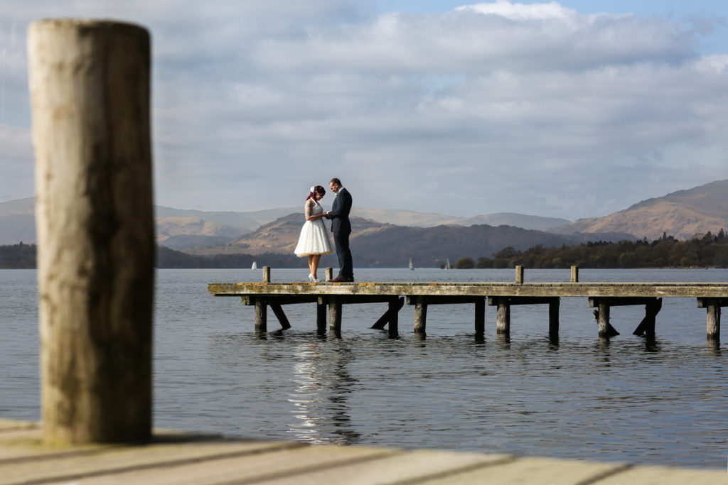 lake district documentary wedding photographer couple on jetty in the sun