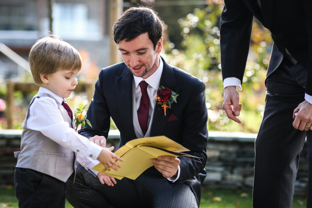 lake district documentary wedding photographer Lodore Falls Hotel groom and son with book