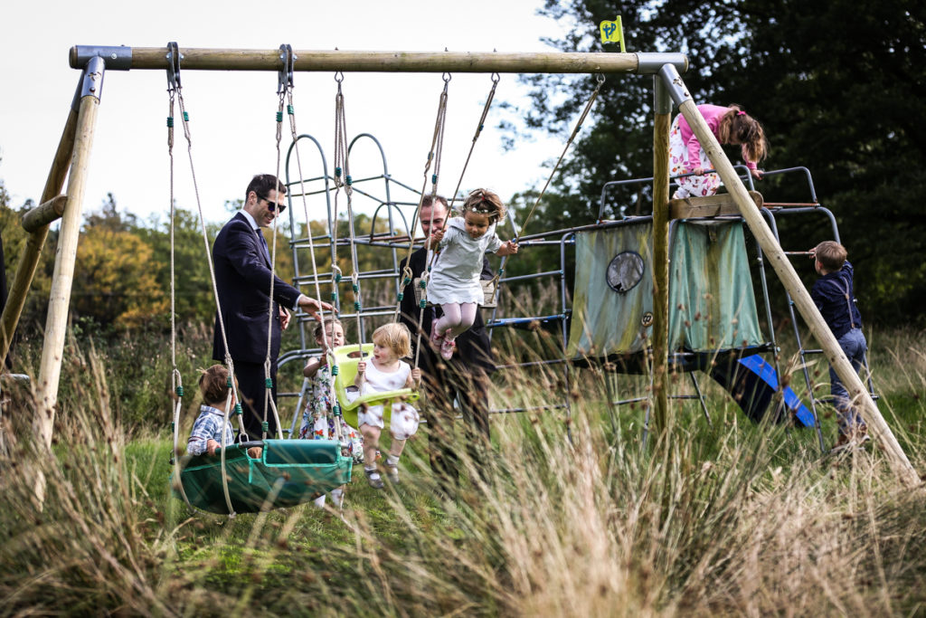 lake district documentary wedding photographer Springkell children on swing set in the summer