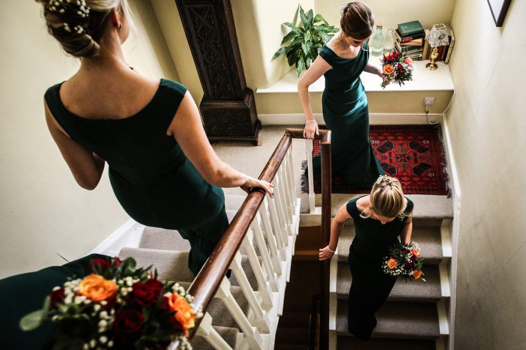 lake district documentary wedding photographer Belmount Hall bridesmaids going down the stairs