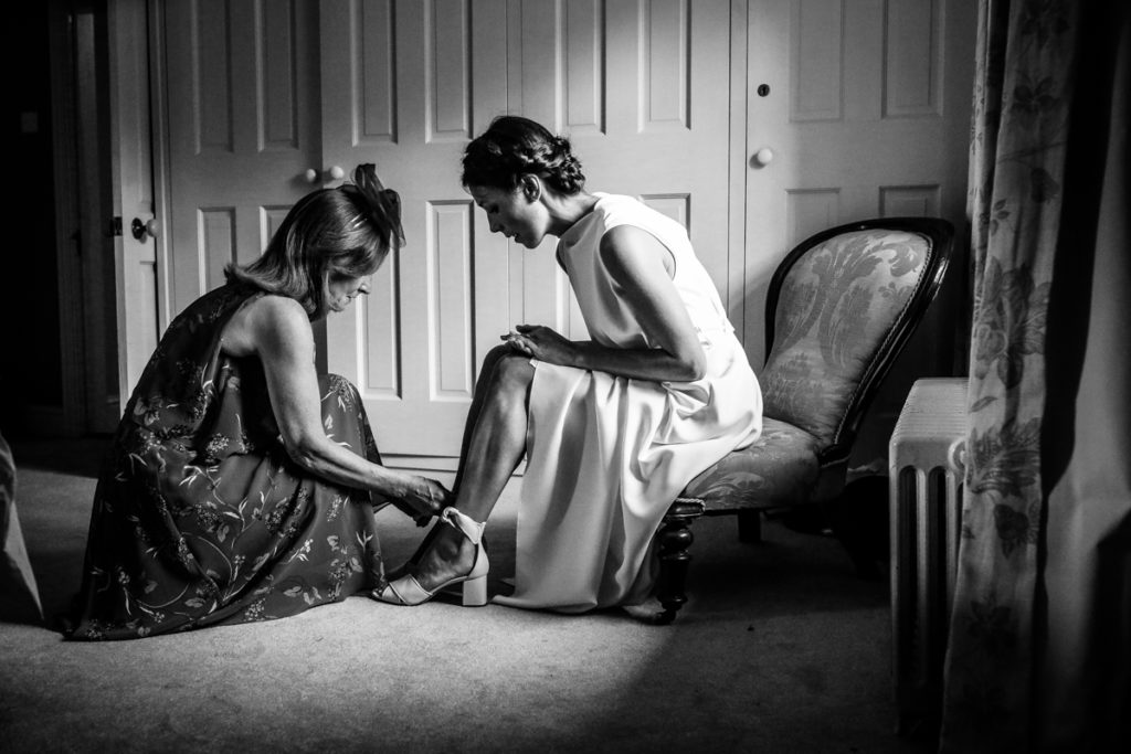 lake district documentary wedding photographer Melmerby Hall bride putting on shoes