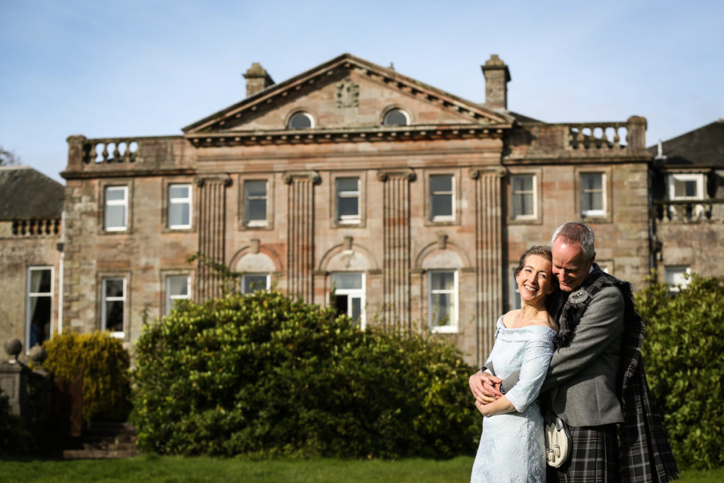 lake district documentary wedding photographer Springkell couple posing in front of the house