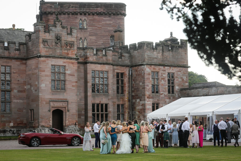 lake district documentary wedding photographer Greystoke Castle wedding guests on the lawn