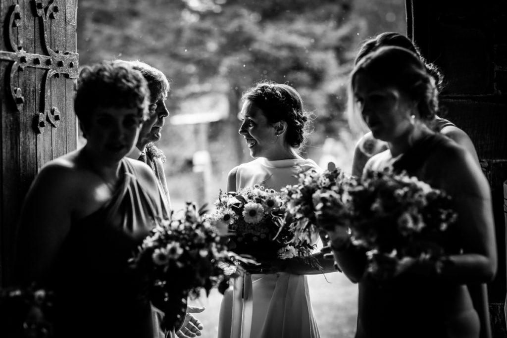 lake district documentary wedding photographer church bride and fathers entrance in black and white