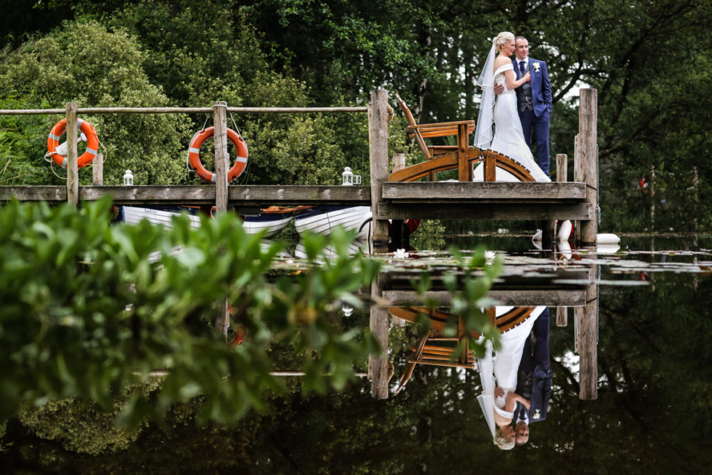 lake district documentary wedding photographer Gilpin Lake House couple on jetty portrait with reflection