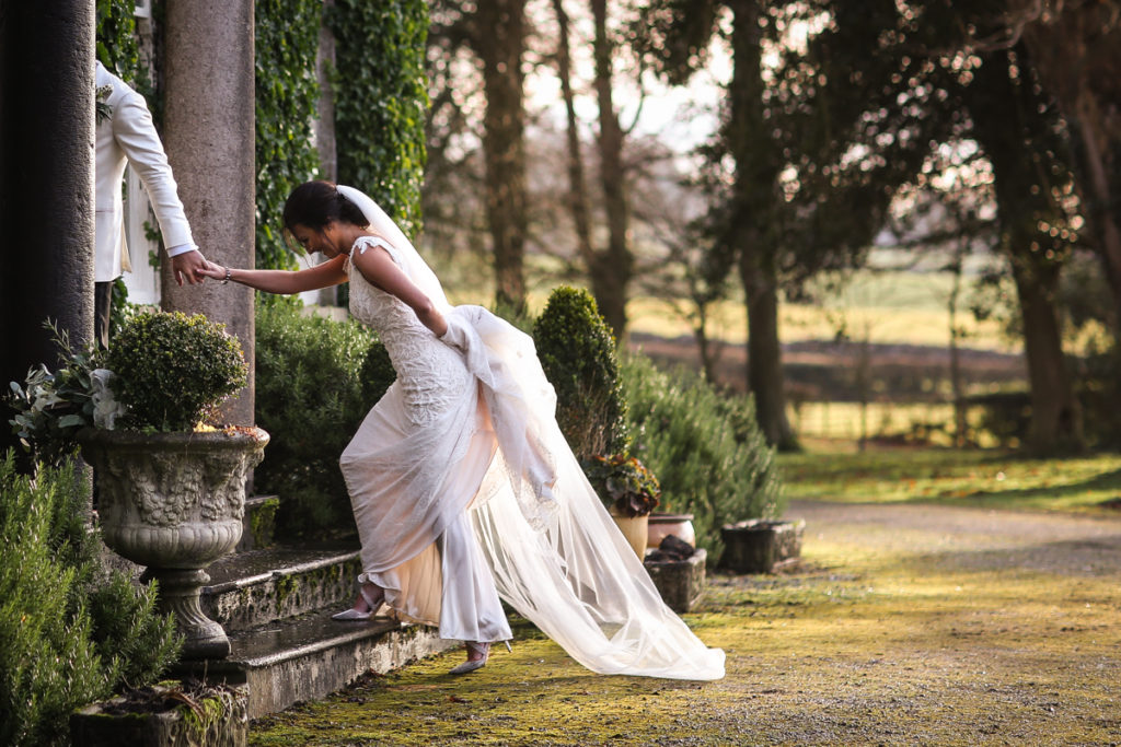 lake district documentary wedding photographer Longlands bride and groom in winter light walking up the steps into the house